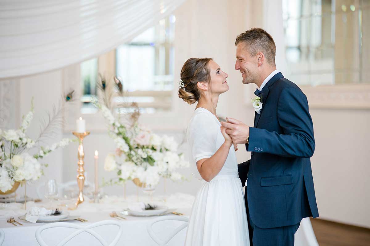 Brautpaar vor dem geschmückten Hochzeitstisch